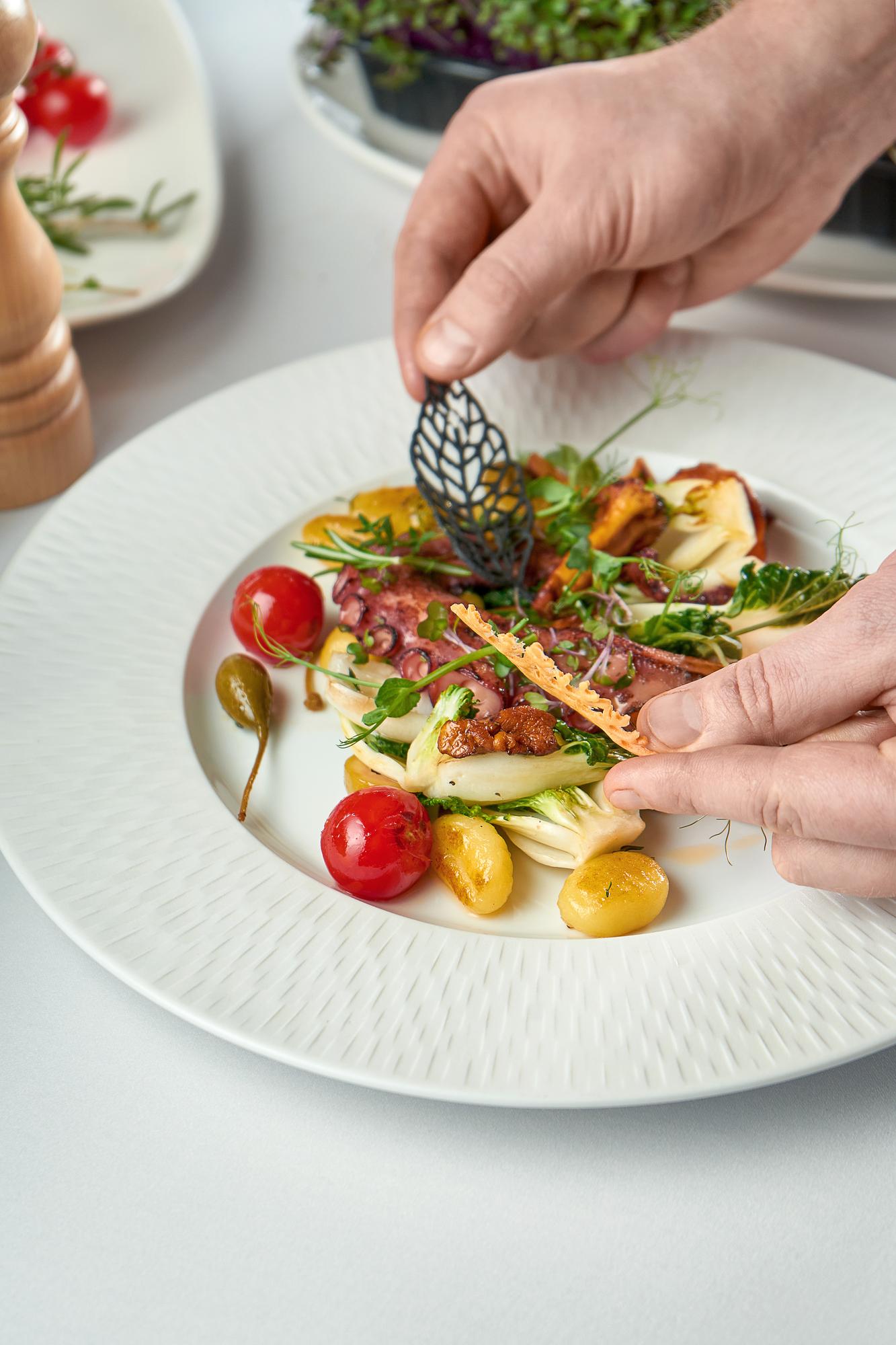 Chef plating a composed seasonal dish